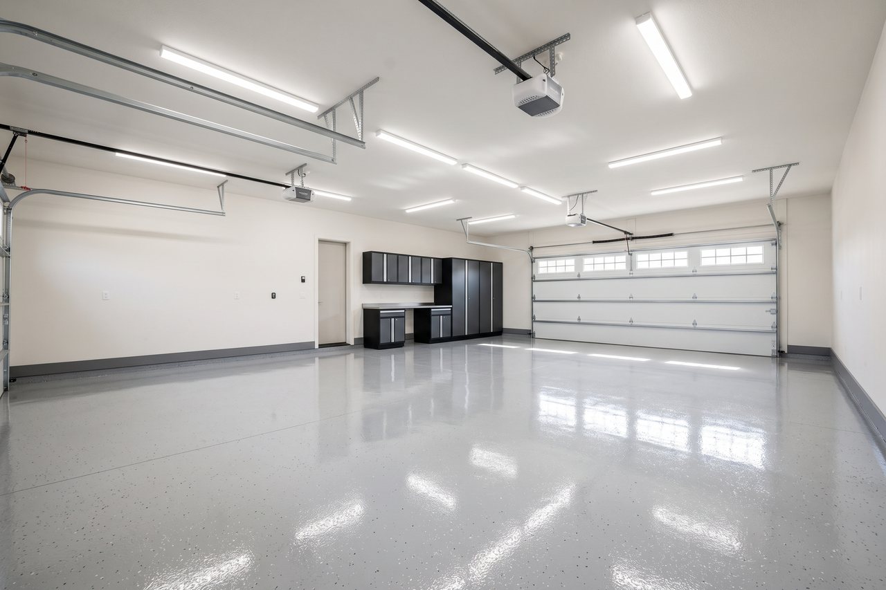 Finished epoxy-coated garage floor with a clean, smooth surface and bright overhead lighting